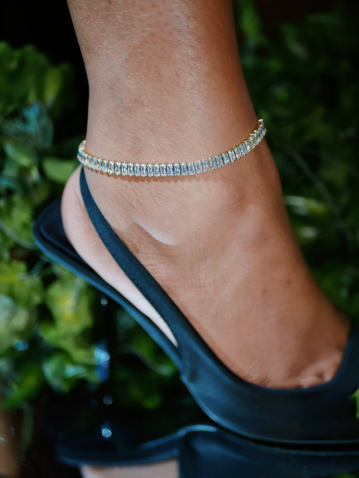 14K Gold Baguette Diamond Tennis Anklet crafted in stainless steel with sparkling baguette stones. A luxury gold ankle bracelet perfect for summer style.
