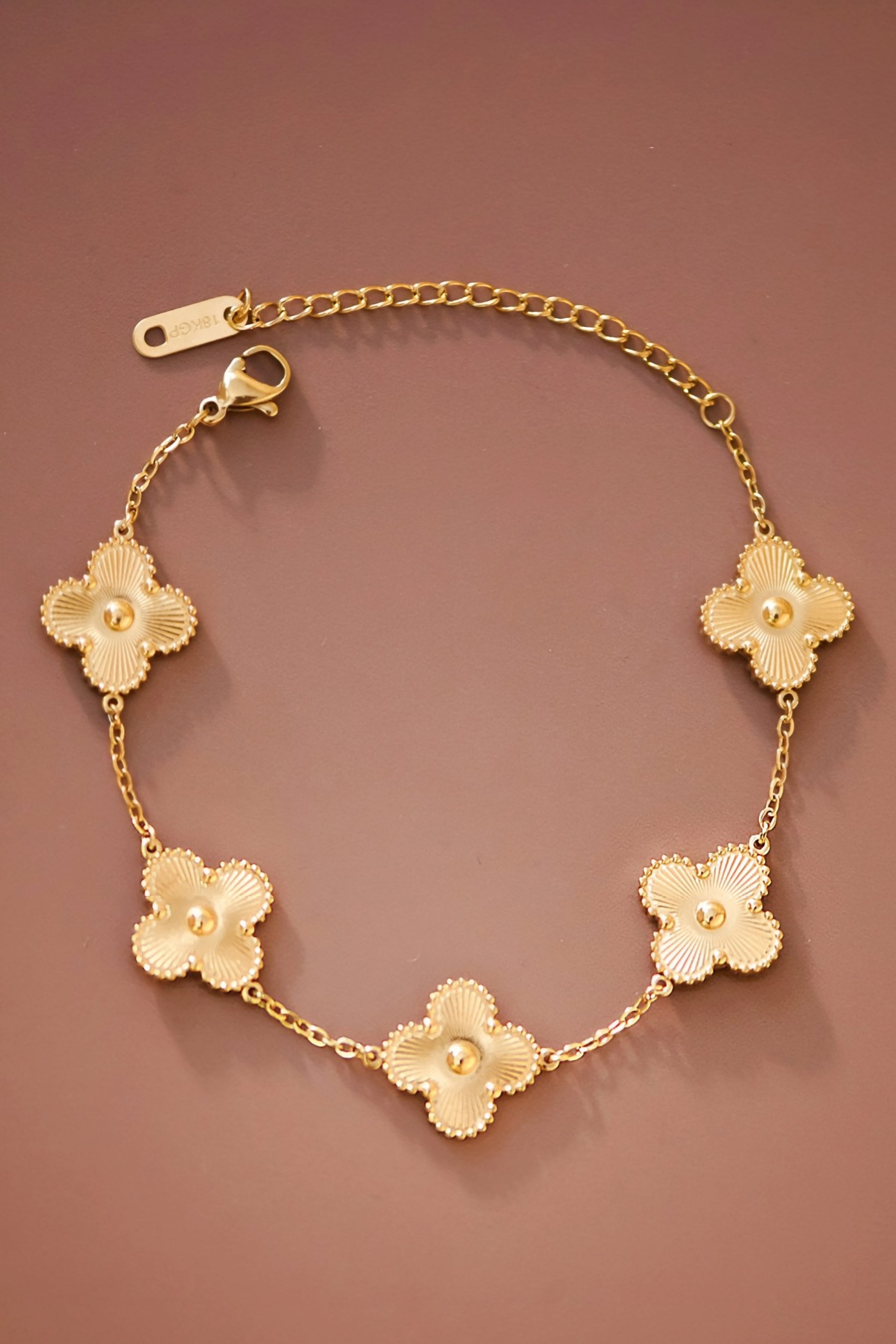 <!-- Product on white background -->
<img src="your-image-url-1.jpg" alt="18K gold plated clover bracelet with five charm links, designer inspired jewelry" />

<!-- Close-up of clover charms -->
<img src="your-image-url-2.jpg" alt="Close-up of 18K gold clover bracelet showing detailed charm design" />

<!-- Model wearing the bracelet -->
<img src="your-image-url-3.jpg" alt="Model wearing gold clover bracelet, minimalist luxury inspired jewelry"